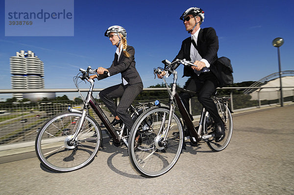 Geschäftsleute auf Elektrorädern  Pedelecs  Olympiagelände  München  Bayern  Deutschland  Europa