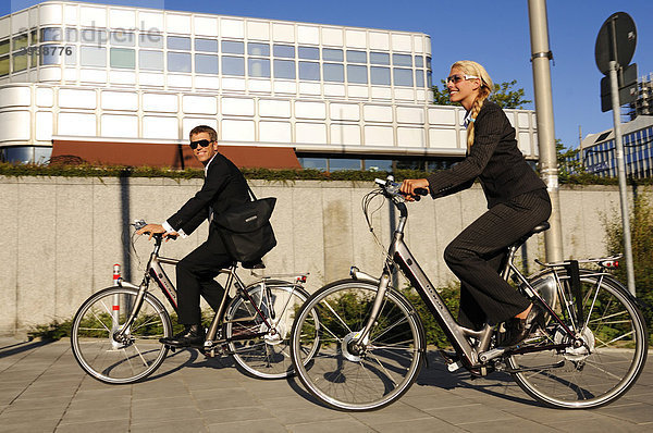 Geschäftsleute auf Elektrorädern  Pedelecs  Hypo-Hochhaus  München  Bayern  Deutschland  Europa