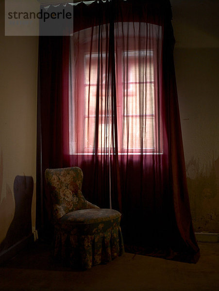 Rokoko-Sessel in einem runtergekommenen Schlafzimmer im Rotlichtmillieu