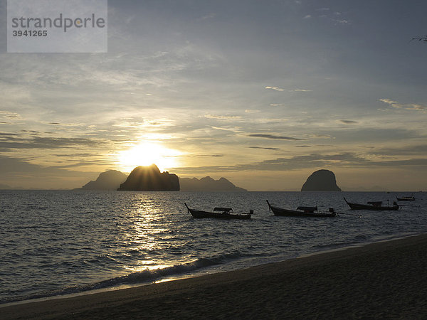 Longtailboote bei Sonnenaufgang mit Blick auf eine Felsengruppe und die Insel Ko Muk vom Strand der Insel Ko Hai  Ko Ngai aus gesehen  Andamanensee  Provinz Satun  Südthailand  Thailand  Asien