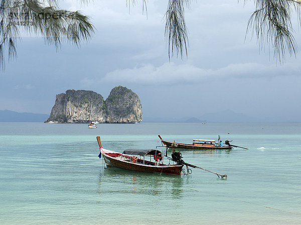 Longtailboote in kristallklarem Meer mit Blick auf eine Felsengruppe  gesehen vom Strand der Insel Ko Hai  Ko Ngai  Andamanensee  Südthailand  Thailand  Asien
