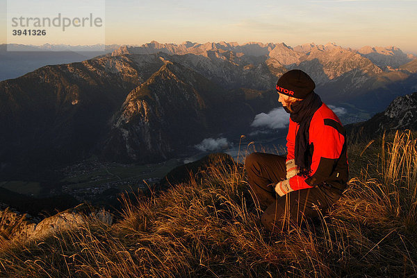 Junge Frau schaut von der Heidachstellwand  2192m  bei Sonnenaufgang  Alpenglühen  hinunter auf den Achensee mit Maurach  Rofan  Achensee  Tirol  Österreich  Europa