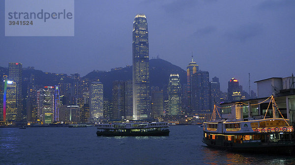 Abendlich erleuchtetes Hongkong mit Wolkenkratzern  Hochhäusern und Bootsanleger der Star Ferry von Hongkong Central und Kowloon  Hongkong  China  Asien