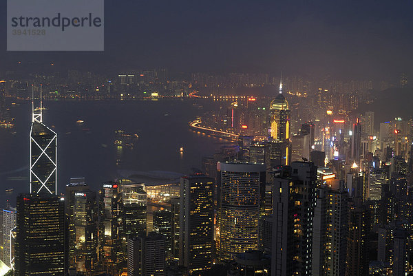 Blick vom Victoria Peak auf das abendlich erleuchtete Hongkong mit Wolkenkratzern und Hochhäusern von Central und Kowloon  Hongkong  China  Asien