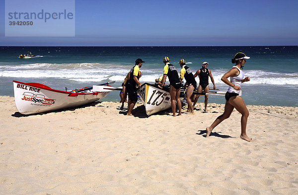 Wettbewerbs-Surfboote und eine laufende Surf Life Saver Rettungsschwimmerin  Scarborough Beach  Perth  Western Australia  Australien