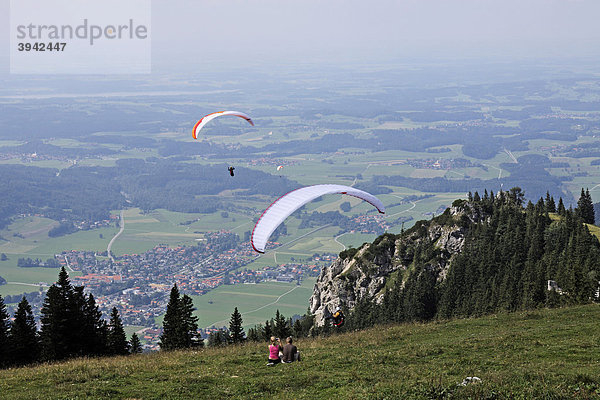 Gleitschirmflieger an der Kampenwand  beobachtet und fotografiert von zwei Leuten  Chiemgau  Oberbayern  Bayern  Deutschland  Europa
