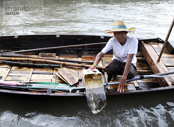 Mann schüttet Wasser aus seinem Boot  Bangkok  Thailand  Asien
