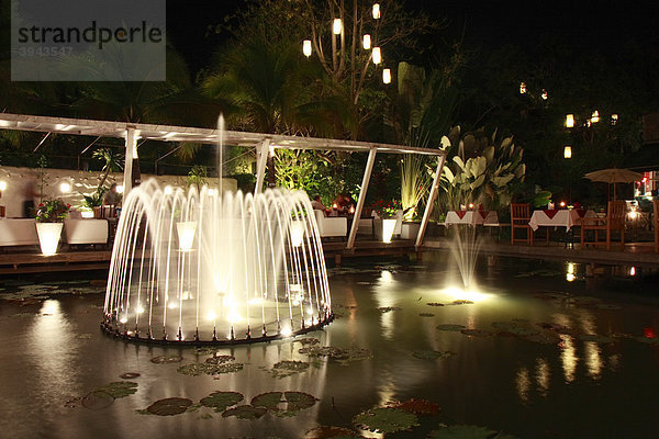 Teich mit Springbrunnen und Lampions abends im Garten eines Restaurants  Chiang Mai  Nordthailand  Thailand  Asien