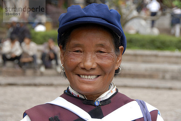 Portrait  Ethnologie  lachende Frau der Naxi Ethnie in Tracht auf dem alten Marktplatz  Nakhi  Altstadt  Lijiang  UNESCO Weltkulturerbe  Provinz Yunnan  Volksrepublik China  Asien