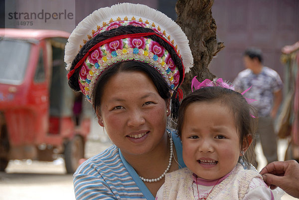 Portrait  Ethnologie  Frau der Bai Ethnie mit typischem Kopfschmuck und Kleinkind  Yongning  Lugu Hu See Gebiet  Provinz Yunnan  Volksrepublik China  Asien