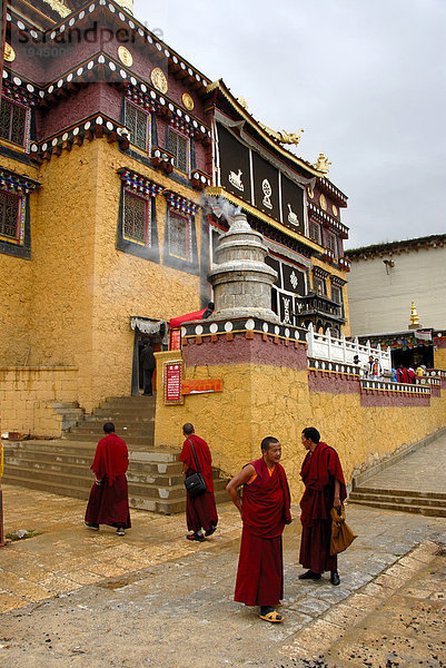 Tibetischer Buddhismus  Mönche in roter Robe vor Tempel  Kloster Ganden Sumtseling Gompa  Zhongdian  Shangri-La  Provinz Yunnan  Volksrepublik China  Asien