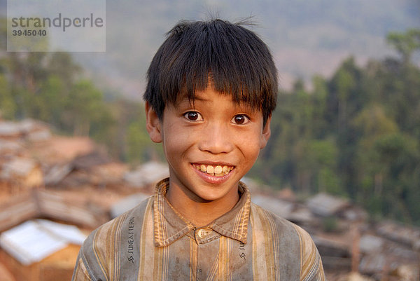 Armut  Portrait  Ethnologie  Junge der Akha Djepia Ethnie lächelt mit großen Augen  Dorf Ban Chakhamdaeng  bei Nam Lan Conservation Area  Distrikt Boun Tai  Provinz Phongsali  Phongsaly  Laos  Südostasien  Asien
