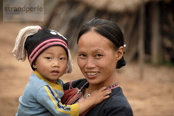 Armut  Portrait  Ethnologie  Frau der Yao Ethnie gekleidet in Tracht lacht  Mutter mit Baby im Arm  Dorf Ban Houeyyoum  Distrikt Gnot Ou  Yot Ou  Provinz Phongsali  Phongsaly  Laos  Südostasien  Asien