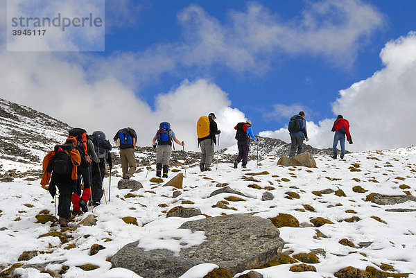 Trekking  Trekkinggruppe  Gruppe Wanderer  hintereinander bergauf  Pfad durch Schnee  Shug-La Pass 5250 m  alter Pilgerweg durchs Hochgebirge von Kloster Ganden nach Samye  Himalaya  Autonomes Gebiet Tibet  Volksrepublik China  Asien