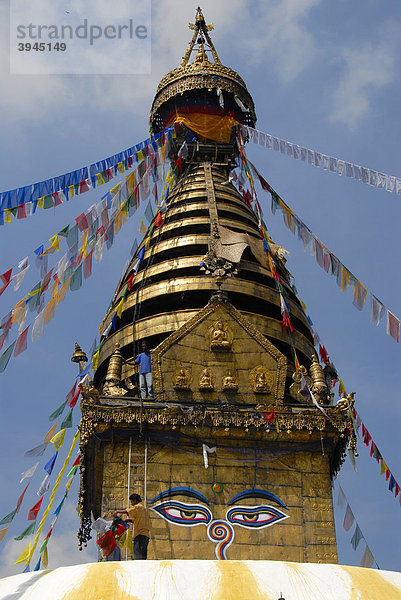 UNESCO Weltkulturerbe  tibetischer Buddhismus  Architektur  Stupa Swayambhunath  zwei Augen blicken herab  Männer hängen bunte Gebetsfahnen auf  Kathmandu  Nepal  Himalaya  Asien
