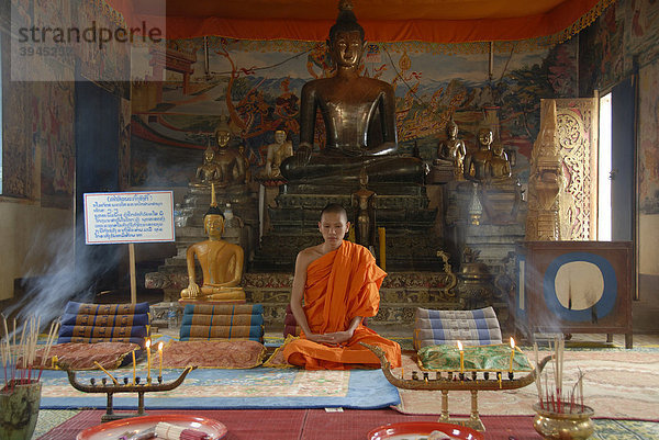 Theravada Buddhismus  Mönch im Tempel  alte Buddha-Statue aus Bronze  Meditation  Bhumisparsha Mudra  Bhumisparshamudra  Geste der Erdanrufung  Wat Phosainaram Wat Ongteu  Xam Neua  Provinz Houaphan  Laos  Südostasien  Asien