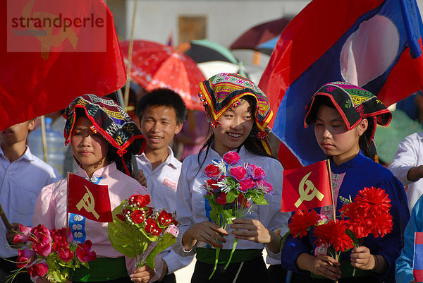 Festival  Mädchen der Tai Dam Ethnie  traditionelle Kleidung  rote Fähnchen der kommunistischen Partei  Nationalflagge von Laos  Xam Neua  Provinz Houaphan  Laos  Südostasien  Asien
