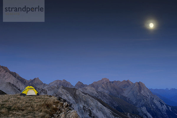 Zelt auf Hochfläche vor Alpengipfeln mit Vollmond  Kaisers  Lechtal  Außerfern  Tirol  Östereich  Europa