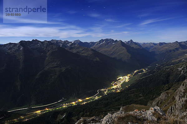 Alpengipfel mit beleuchtetem Tal bei blauer Stunde  St. Anton  Lechtal  Außerfern  Tirol  Östereich  Europa