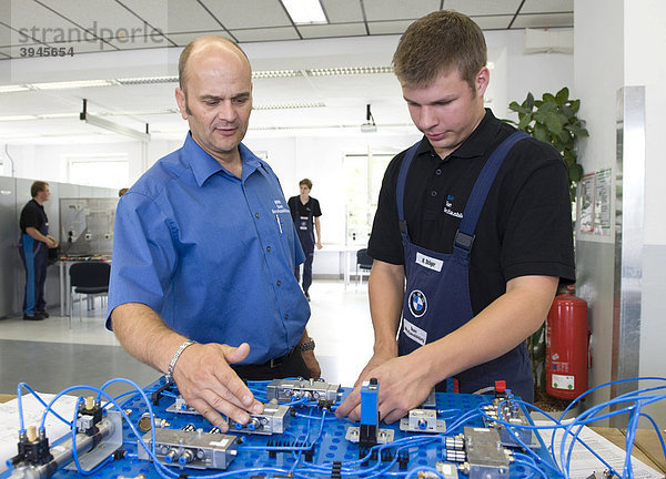 Im BMW-Ausbildungszentrum für Kfz-Mechatroniker erklärt Meister Andreas Fischer einem Auszubildenden eine elektrische Schaltung  München  Bayern  Deutschland  Europa