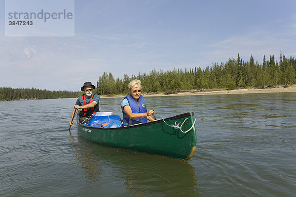 Älteres Paar  Mann und Frau paddeln ein Kanu  Kanufahren  oberer Liard River Fluss  Yukon Territory  Kanada