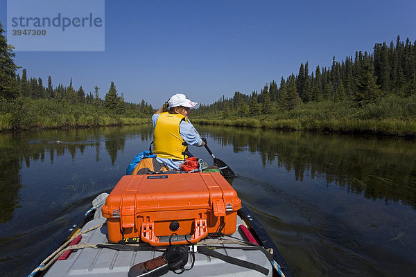 Junge Frau sitzt  paddelt im Kanu  oberer Liard River  Yukon Territory  Kanada