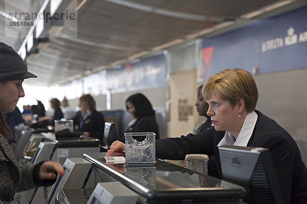 Angestellte checkt eine Reisende ein am Abfertigungsschalter der Delta  Northwest Airlines  Detroit Metropolitan Airport Flughafen  Romulus  Michigan  USA
