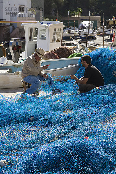 Zwei Fischer flicken ihre Netze im Hafen von Cala Figuera  Mallorca  Balearen  Mittelmeer  Spanien  Europa