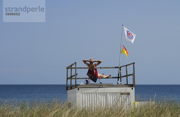 Posten der Wasserrettung sitzt entspannt auf seinem Rettungsturm  Seebad Heringsdorf  Insel Usedom  Mecklenburg-Vorpommern  Deutschland  Europa