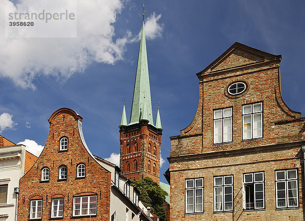 Klassische Bürgerhäuser mit typischen Giebeln an der Obertrave  hinten die Kirche St. Petri  Lübeck  Schleswig-Holstein  Deutschland  Europa
