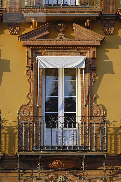 Ein Fenster und ein Balkon an einer prächtigen Fassade  im weichen Abendlicht  Sevilla  Spanien  Europa