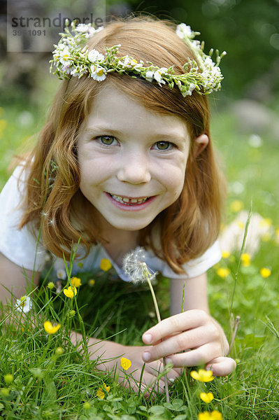 Junges Mädchen mit Blütenkranz im Haar und Löwenzahn Pusteblume