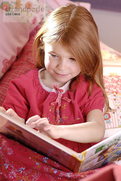 Kleines Mädchen liest in einem Buch  Bilderbuch