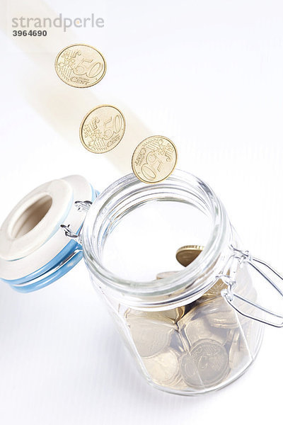 Münzen fallen in ein Einmachglas