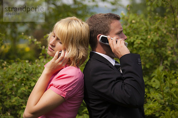 Junge Frau und junger Mann beim Telefonieren