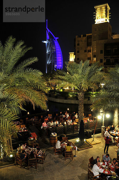 Freiluft-Restaurant des Madinat Jumeirah Resorts vor der beleuchteten Fassade des Sieben-Sterne-Hotels Burj al Arab  Arabischer Turm  Dubai  Vereinigte Arabische Emirate  Arabien  Naher Osten  Orient