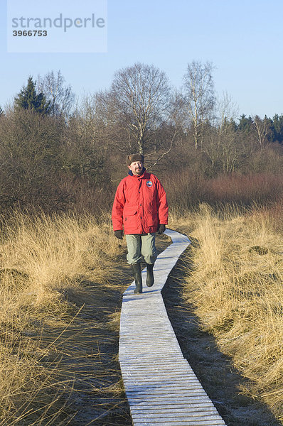 Hohes Venn Naturschutzgebiet im Winter  Wanderer auf einem gefrorenen Holzweg  Eupen  Provinz Lüttich  Belgien