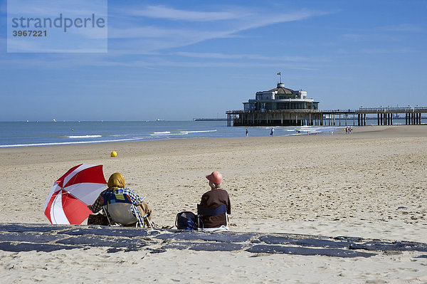 Zwei Frauen sitzen am Strand  Blankenberge Pier  Nordseeküste  Belgien  Europa