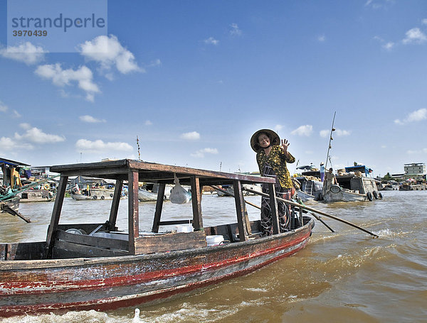 Frau mit traditionellem Hut  Kegelhut aus Palmenblättern  rudert stehend ein Holzboot am Mekong  Mekongdelta  Vietnam  Asien