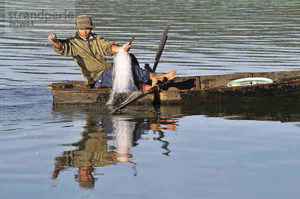 Fischer auf einem Holzboot zieht ein Netz ein am Tuyen Lam See  Dalat  Zentrales Hochland  Vietnam  Asien