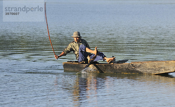 Fischer auf einem Holzboot fischt mit traditioneller Stockschlag-Methode  Tuyen Lam See  Dalat  Zentrales Hochland  Vietnam  Asien