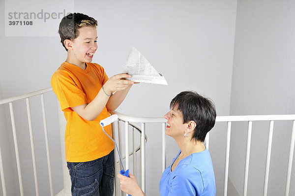 Malerarbeiten  Junge setzt seiner Mutter einen Papierhut auf