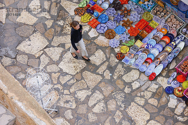 Frau geht an Töpferware vorbei  Marktgasse  Hafenfestung  Kasbah  historische Altstadt  Medina  Hammamet  Tunesien  Nordafrika