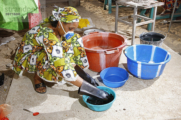 Frau mit Atemschutz mischt Farbe an für Stoffbatik  Heimarbeit  Maroua  Kamerun  Afrika