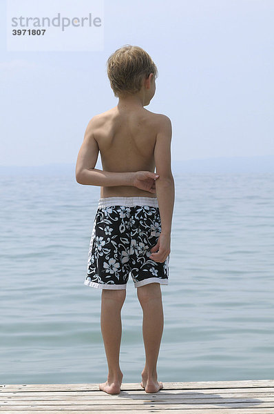 6jähriger Junge steht am Ufer und schaut auf den Gardasee  Italien  Europa