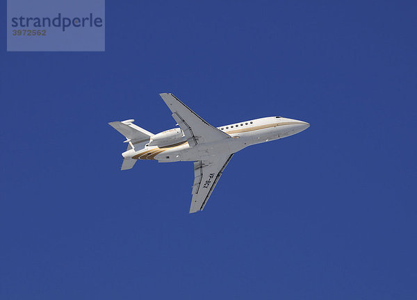 Weißes Verkehrsflugzeug im Steigflug vor stahlblauem Himmel  Perspektive schräg von unten