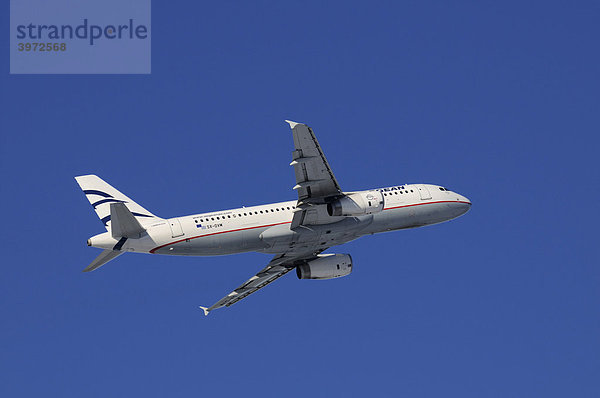 Verkehrsflugzeug der Aegean Airlines  Airbus A320-200  im Steigflug vor stahlblauem Himmel
