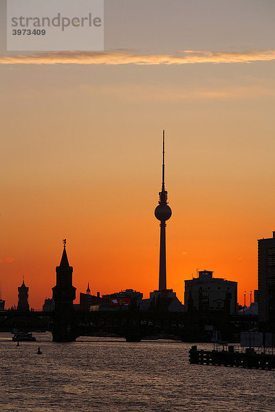 Silhouette der Oberbaumbrücke über die Spree mit Fernsehturm und Rotes Rathaus während Sonnenuntergang in Berlin  Deutschland  Europa