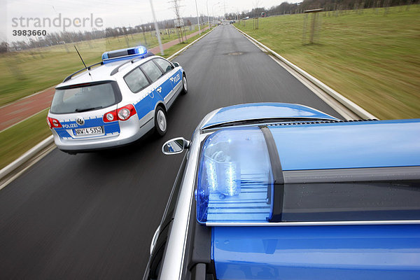 Streifenwagen im blauem Design der Polizei bei einer Alarmfahrt mit Blaulicht