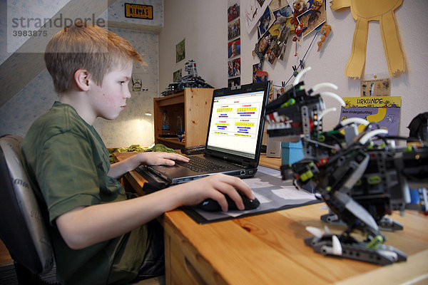 Junge  11 Jahre alt  arbeitet mit seinem Computer zuhause in seinem Kinderzimmer am Schreibtisch  übt für die Schule mit einer Mathematik Lern Software